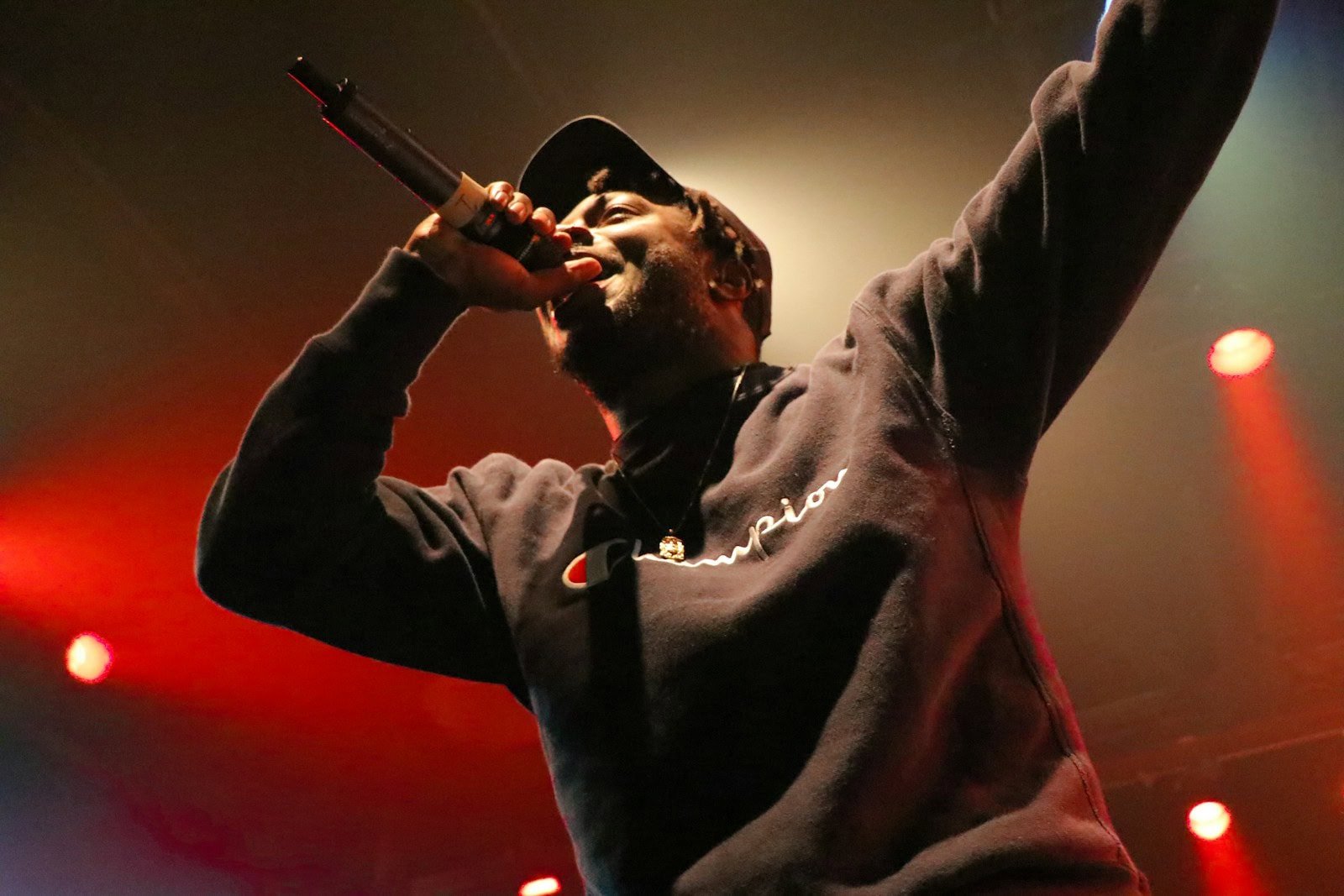 black person holding microphone and singing on stage